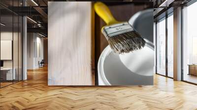 White paint and brush. Painting a textured wooden board. Wall mural