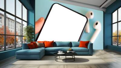 Smartphone blank screen on a colored background with headphones. Wall mural