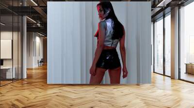 A stylish young woman in a silver top and leather shorts. Photo in futuristic cyberpunk style Wall mural