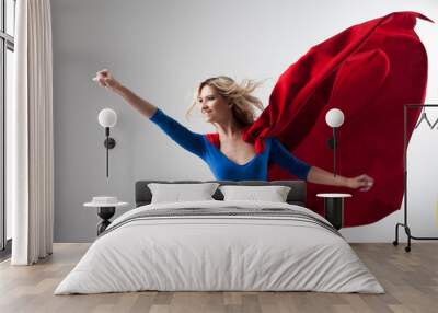 Superhero Woman. Young and beautiful blonde in image of superheroine in red Cape growing Wall mural