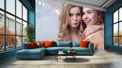 Two happy friends with trendy makeup using glitter on their face. Wall mural