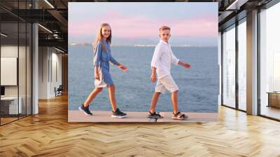 brother and sister siblings kids walk on sunset on sea background full body photo Wall mural