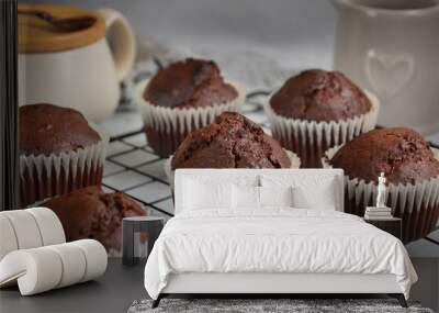 Chocolate muffins in a white paper capsule, standing on the grate. Wall mural