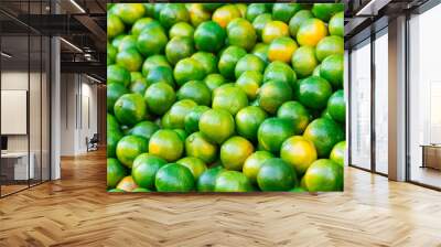 Close up fresh green mandarins in market. It can be used as a food background (selective focus) Wall mural