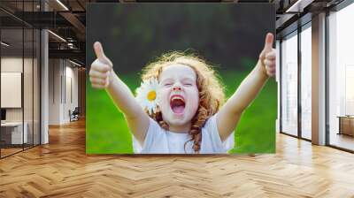 Laughing girl showing thumbs up. Wall mural