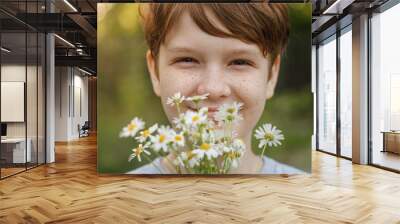 Smiling child with a bouquet of white daisy. Wall mural