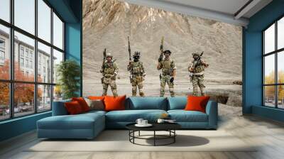 A group of military men in combat gear patrol in the middle of a desert and tropical jungle. Soldiers in full combat gear in dry weather conditions assemble and march on a mission. Wall mural