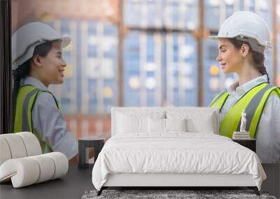 Group of Diversity factory worker women meeting to inspect containers logistic in warehouse. Asian, and white caucasian people make a deal and shaking hands on site cargo for logistic shipping area. Wall mural