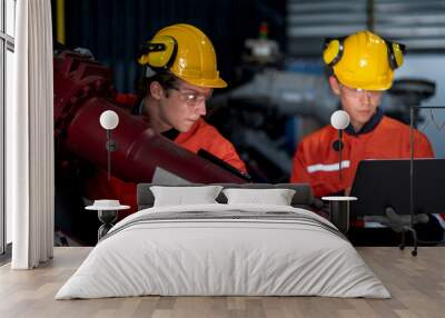 group of male engineer workers maintenance automatic robotic arm machine in a dark room factory. worker checking and repairing automatic robot hand machine. Worker wearing safety glasses and helmet. Wall mural