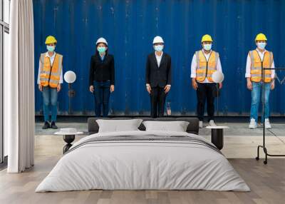 group people worker is wearing protection mask face and safety helmet and wearing suit safety dress With background cargo warehouse. industry worker operating. people have a social distancing space. Wall mural