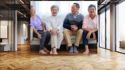 Happiness of the group females and male elderly sitting on the sofa. Senior people are talking and enjoy together at the living room. Joyful carefree retired senior friends enjoying relaxation. Wall mural