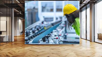 Portrait of African woman worker beautiful face with eye confident and wearing working suite dress and safety helmet at heavy machine in industry factory. Engineer  worker concentrate on workplace. Wall mural