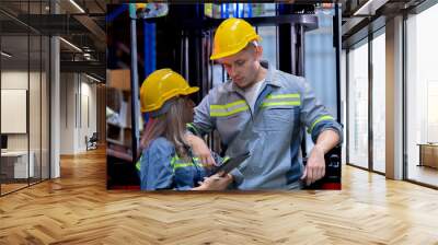 Two male and female factory checkers are discussing work on a warehouse truck. While working in a warehouse for industrial products Wall mural