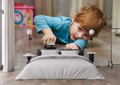 little boy plays with toy car at home Wall mural