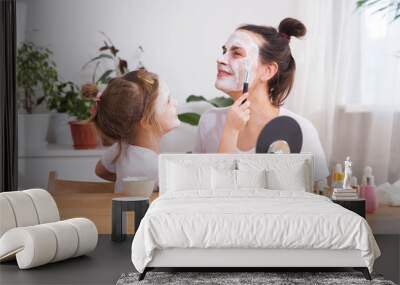 Morning skin care. mom and little daughter have fun spending time together at home. Happy family mother and child daughter make face skin mask together.  Wall mural