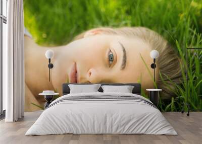 portrait of the young beautiful woman of the vacationer on a grass in park Wall mural