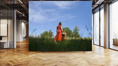 Slow life. Enjoying the little things. spends time in nature in summer. happy middle aged woman wearing an orange dress and straw hat relaxed outdoors. copy space. concept without stress. mental healt Wall mural