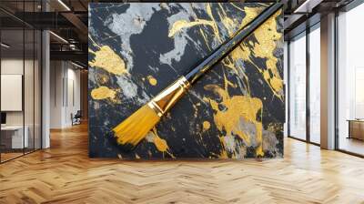 A paintbrush on a textured, gold-splattered surface. Wall mural