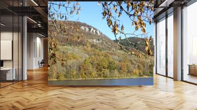 Happurger Stausee water reservoir with hills, colorful forest and rocks on a sunny autumn day Wall mural