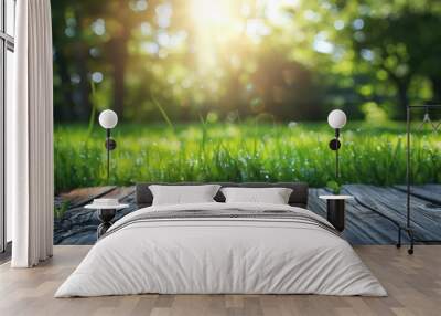 Beautiful natural background with flooring from old wooden boards and young green juicy grass in the sun with bokeh effect Wall mural