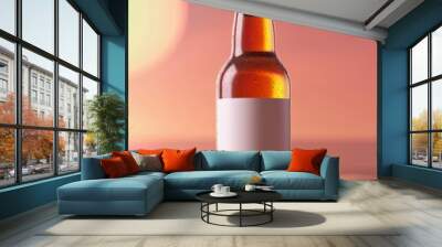 Chilled beer bottle with blank label on sandy beach at sunset. Wall mural