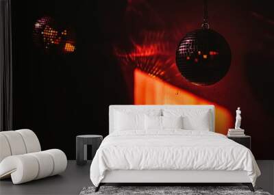 Two disco balls with light reflections create a vibrant atmosphere in a dimly lit space. Wall mural