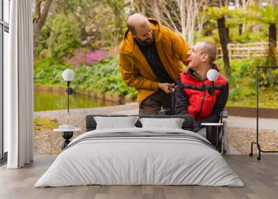 a person with a disability in the wheelchair being pushed by a friend in a public city park, having fun in spring Wall mural