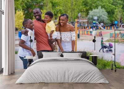 African black ethnicity family having fun with happy children together in playground, greeting each other after school Wall mural