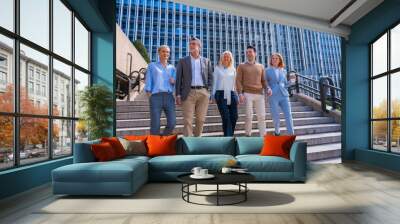 Cheerful group of coworkers outdoors in a corporate office area going down some stairs going to work Wall mural