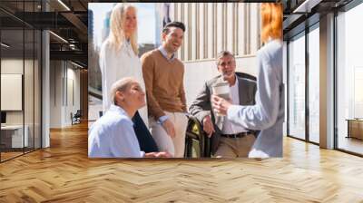 Cheerful group of coworkers outdoors in a corporate office area resting and laughing on a sunny morning Wall mural