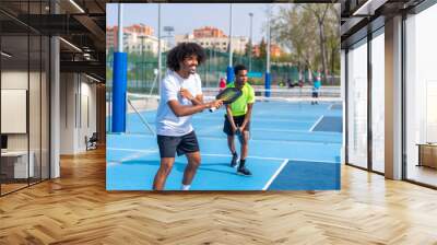 Friends enjoying playing pickleball together in an outdoor court Wall mural