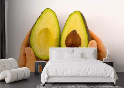 Hands of a woman separating the avocado in two. Recipe to prepare a nice guacamole Wall mural