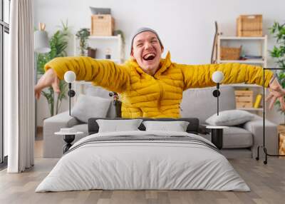 Happy disabled man in wheelchair laughing at camera at home Wall mural