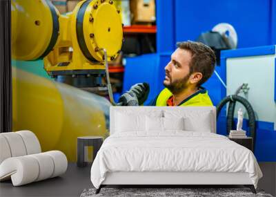 Mechanic repairing a piece of a robotic arm Wall mural