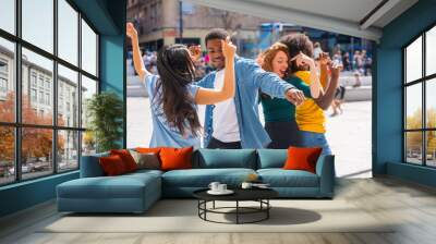 Multi ethnic young friends dancing in a city square, group of diverse friends having fun Wall mural