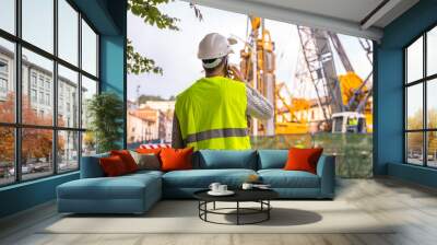 Technician engineer observing the team of workers at the construction site in the city Wall mural