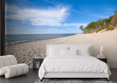 Empty, sandy beach and sea waves by sunny day Wall mural