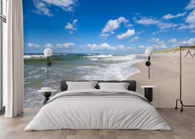 Empty, sandy beach and sea waves by sunny day Wall mural