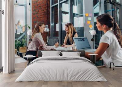 Business partners having a meeting sitting at desk with laptops in conference room Wall mural