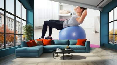 Fitness young woman doing abdominal crunches on fit ball. Wall mural