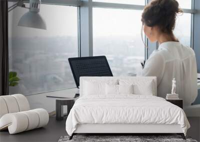 woman wearing office suit sitting at her workplace, typing, searching new ideas for project. female  Wall mural