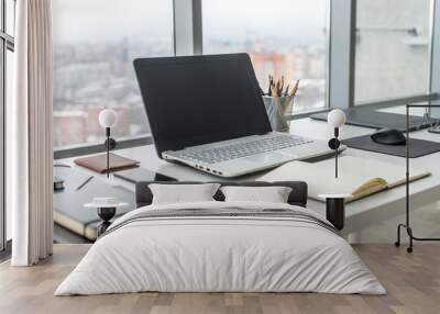 workplace with notebook laptop comfortable work table in office windows and city view. Wall mural