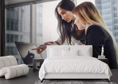 Young woman helping student explaining information pointing at screen of laptop during IT course in classroom Wall mural