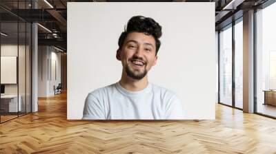 Portrait of a young man with braces smiling and laughing. A happy young man with braces on a white background Wall mural