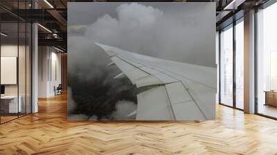 Airplane wing view from the plane to the sky, clouds, earth from a height of flight. Wall mural