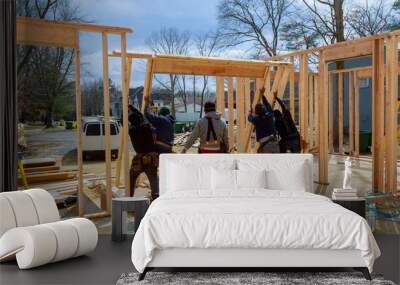 Construction Worker Using nail gun On wood building frame against Wall mural