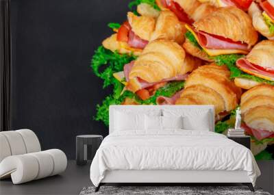 Croissant sandwich with salami on a green wooden background. Wall mural