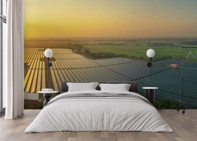 Panorama view of Solar Farm (solar cell) at sunset sky background with electric power generation in agricultural area . Renewable green alternative energy. Power plant. Solar photovoltaic rows fields. Wall mural