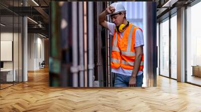 Tired engineer or upset disappointed factory worker, in container yard. Wall mural