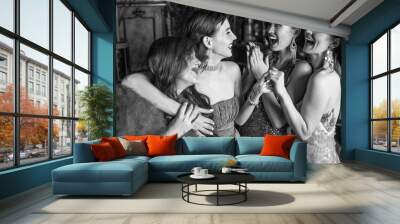 Group of young laughing stylish girls dressed classical style in interior of luxury club. Black-white photo. Wall mural